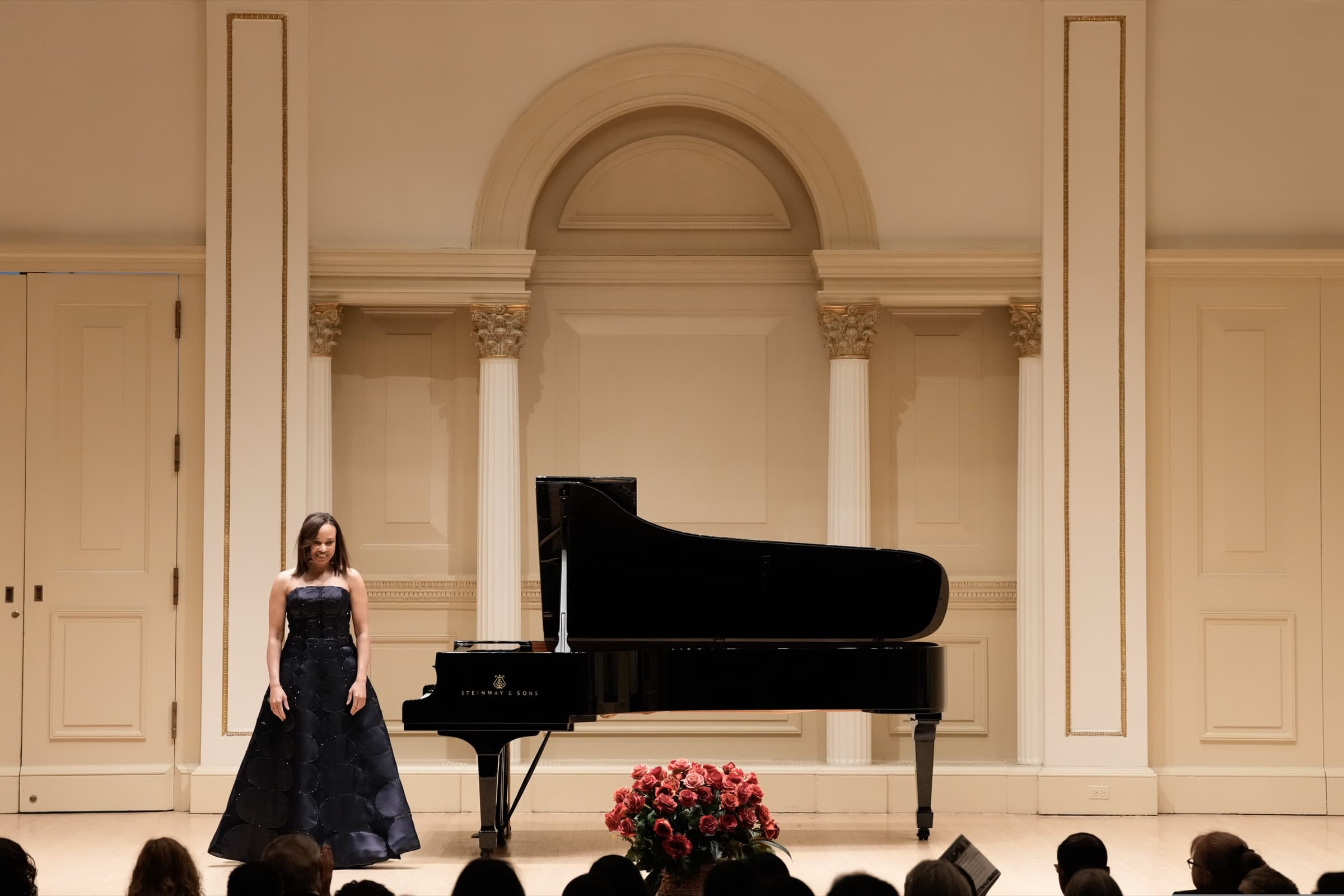 Nina Kidd onstage acknowledgement beside the piano at Carnegie Hall