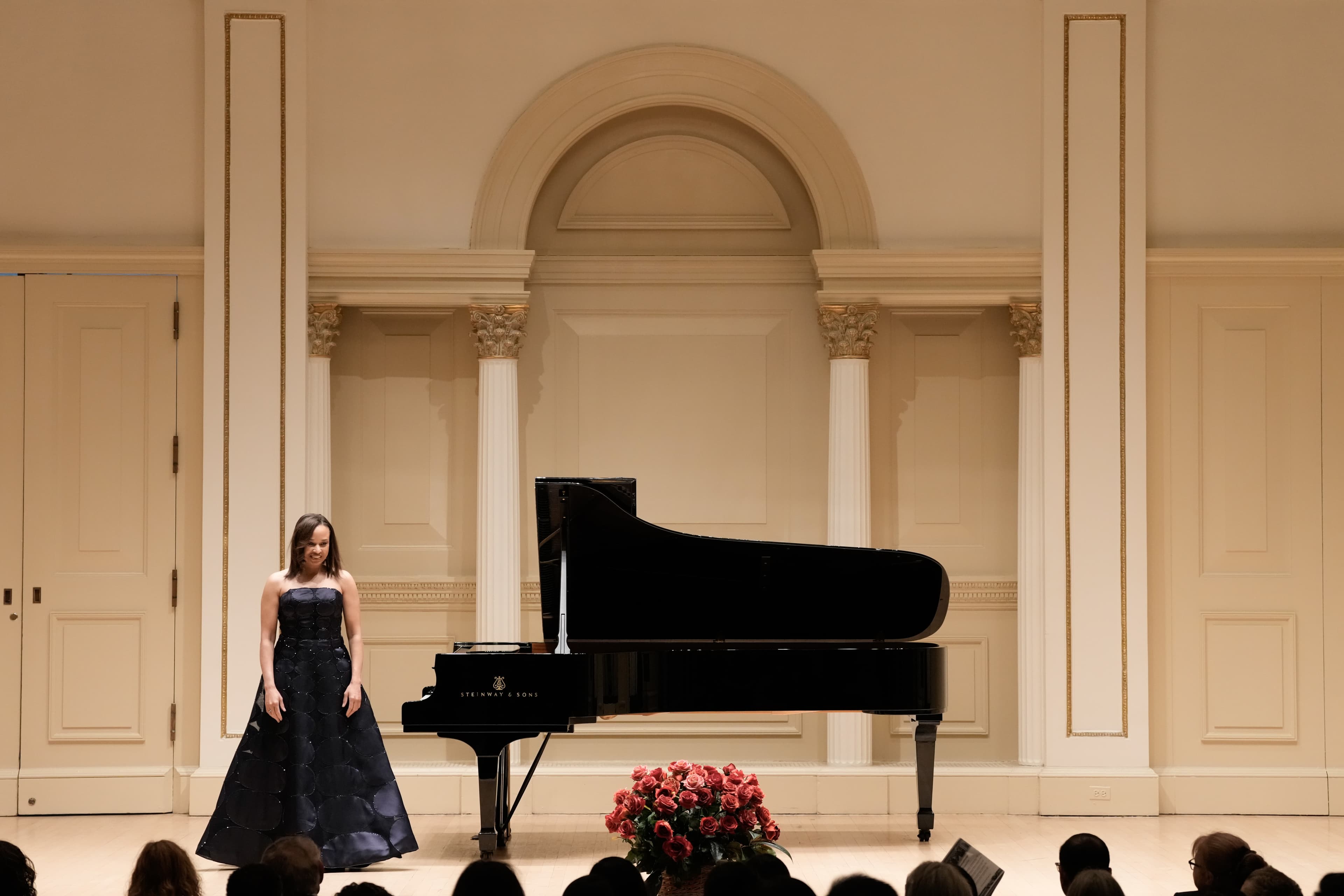 Nina Kidd standing next to the piano